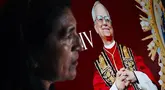 Seorang wanita berdiri di samping gambar Robert Francis Prevost, yang menjadi Paus Leo XIV pada tanggal 8 Mei 2025, di depan katedral Chiclayo di utara Lima pada hari pemilihannya sebagai paus ke-267 Gereja Katolik. (ERNESTO BENAVIDES/AFP)