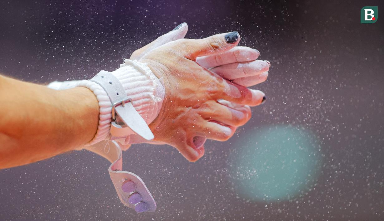 Seorang pesenam sedang memakaikan bubuk di tangannya saat babak kualifikasi Kejuaraan Dunia Gimnastik 2025 di Indonesia Arena, Senayan, Jakarta, Minggu (19/10/2025). (Bola.com/Bagaskara Lazuardi)