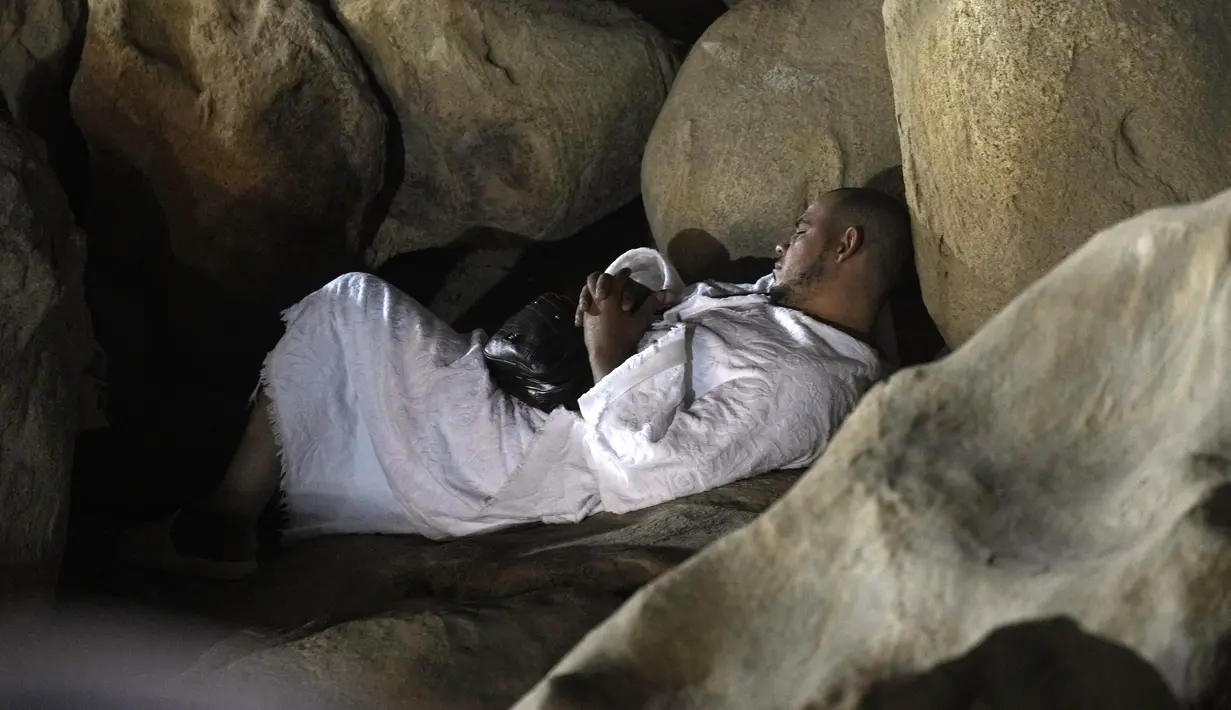 Seorang jemaaah haji beristirahat di Jabal Rahmah, Padang Arafah, dekat Kota Suci Mekkah, Arab Saudi, 8 Juli 2022. Jemaah haji terlebih dahulu berisitirahat sebelum melaksanakan ibadah. (AP Photo/Amr Nabil)