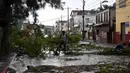 Seorang pria bersepeda melewati jalan yang terhalang oleh cabang-cabang pohon tumbang setelah Badai Lisa di Ladyville, dekat Belize City, Belize, 3 November 2022. Badai Tropis Lisa menyebabkan banjir dan membuat sebagian negara itu menjadi gelap gulita. (Johan ORDONEZ/AFP)
