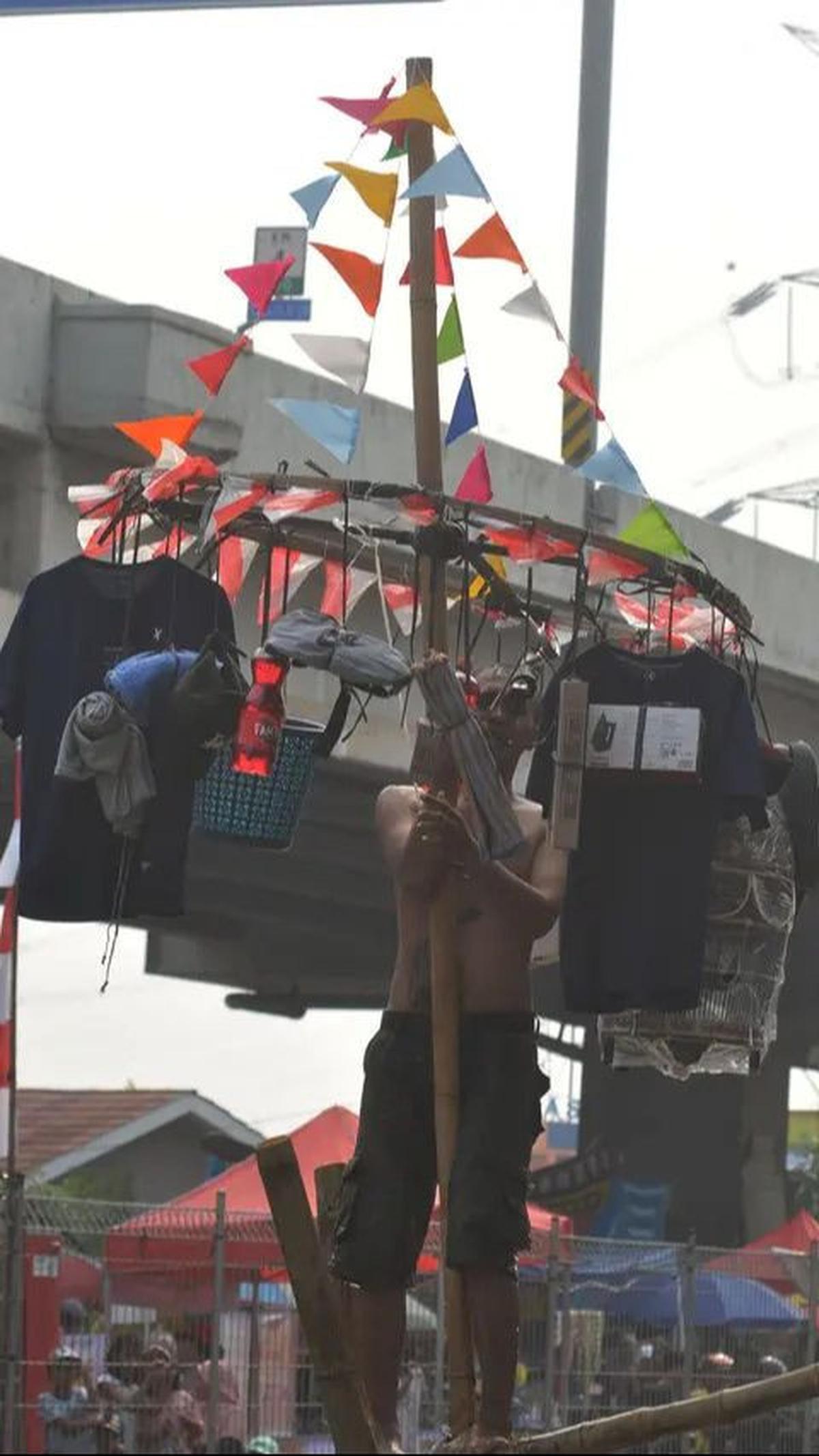Dalam lomba titian bambu, para peserta harus dapat menjaga keseimbangannya di atas bilah batang bambu setinggi 5 meter yang dibentangkan di atas aliran Kalimalang.&nbsp;Foto: Merdeka.com/Imam Buhori