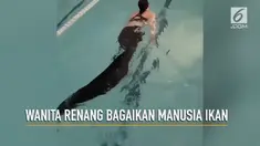Seorang wanita berenang menggunakan pakaian yang tak biasa, sehingga terlihat seperti manusia ikan.