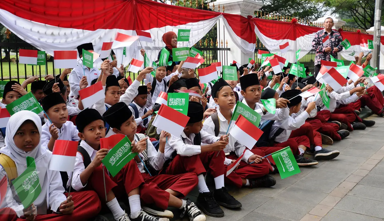 Pelajar SD mengibarkan bendera kedua negara untuk menyambut kedatangan Presiden Joko Widodo bersama Raja Arab Saudi, Salman bin Abdulaziz di sekitar Istana Bogor, Rabu (1/3). Puluhan ribu pelajar akan menyambut. (Liputan6.com/Helmi Fithriansyah)