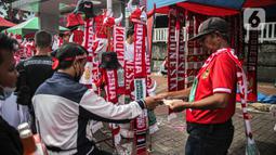 Pedagang menjual atribut timnas Indonesia jelang pertandingan AFF 2022 antara Indonesia melawan Thailand di Stadion Gelora Bung Karno, Jakarta, Kamis (29/12/2022). Atribut timnas Indonesia seperti kaos, syal, dan topi dijual dengan kisaran harga Rp35.000 hingga Rp75.000. (Liputan6.com/Faizal Fanani)