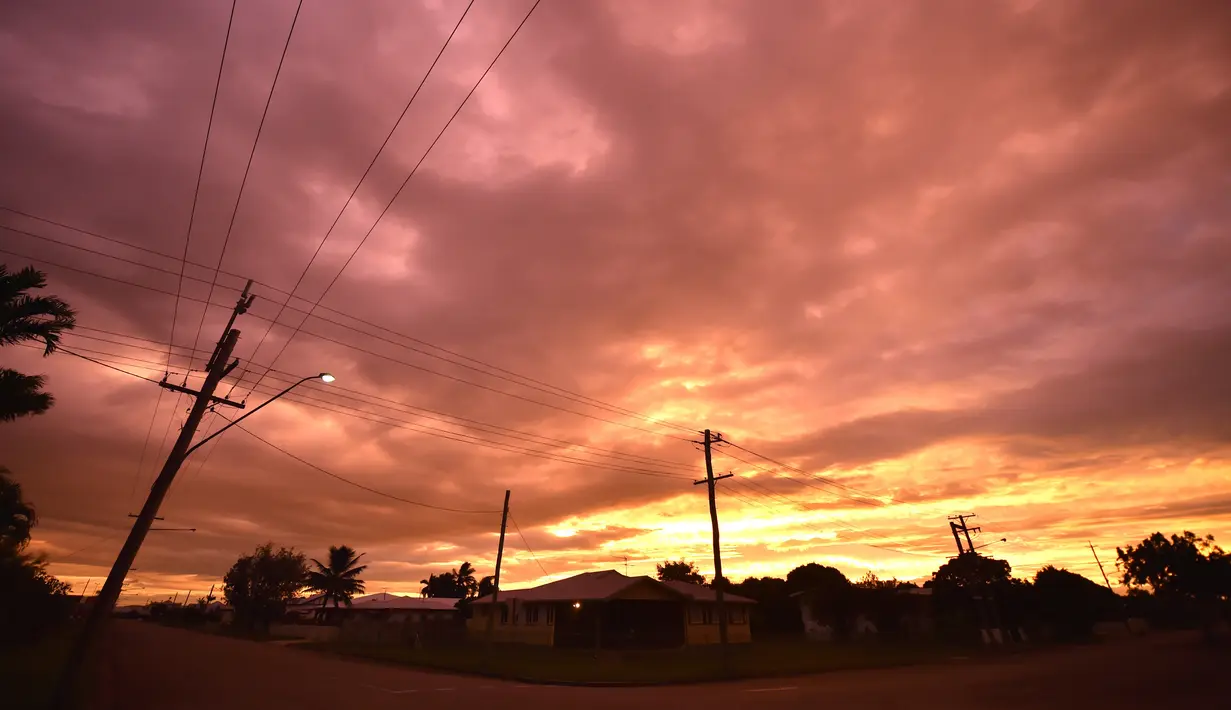 Awan badai berkumpul di kota Ayr di utara Queensland sebelum terjadi Topan Debbie, Australia (27/3). Pihak berwenang juga memperingatkan, topan tersebut dapat menyebabkan gelombang setinggi delapan meter, dan banjir.  (AFP/Peter Parks)