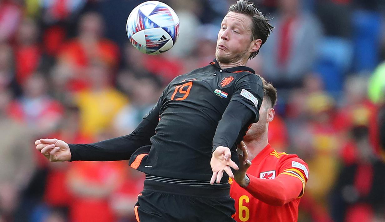 Striker Belanda, Wout Weghorst mengontrol bola dari kawalan bek Wales, Joe Rodon selama pertandingan grup A4 UEFA Nations League di stadion Cardiff City di Cardiff, Wales selatan, Kamis (9/6/2022). Belanda menang tipis atas Wales 2-1. (AFP/Geoff Caddick)