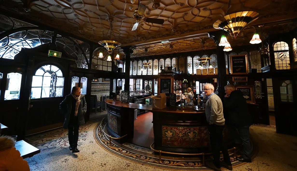 Orang-orang minum di pub Philharmonic Dining Rooms di Liverpool, Inggris pada 11 Februari 2020. Pub yang mendapat sebutan The Phil itu dibangun pada tahun 1898 oleh arsitek Walter W Thomas selama "zaman keemasan" pub di abad ke-19. (Paul ELLIS / AFP)