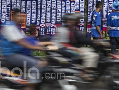 Aremania melihat-lihat atribut Arema FC yang dijual oleh pedagang kaki lima jelang laga semifinal Piala Presiden 2017 antara Arema FC melawan Semen Padang di sekitar Stadion Kanjuruhan, Malang, Jawa Timur, Minggu (5/3/2017). (Bola.com/Vitalis Yogi Trisna)