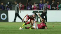 Pemain Timnas Indonesia U-23, Rezaldi Hehanussa (kanan) menghalau bola dari kaki pemain Bahrain pada laga PSSI Anniversary Cup 2018 di Stadion Pakansari, Bogor, (26/4/2018). Bahrain unggul sementara 1-0. (Bola.com/Nick Hanoatubun)