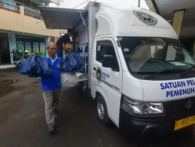 Petugas Satuan Pelayanan Pemenuhan Gizi (SPPG) saat mendistribusikan makanan program Makan Bergizi Gratis (MBG) Ramadan di SDI Al Hidayah, Cinere, Depok, Selasa (24/2/2026). Program Makan Bergizi Gratis (MBG) tetap berjalan selama bulan Ramadan 2026 (1447 H). (merdeka.com/Arie Basuki)