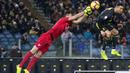 Striker Juventus, Cristiano Ronaldo, berebut bola dengan kiper Lazio, Thomas Strakosha, pada laga Serie A di Stadion Olympic, Minggu (27/1). Juventus menang 2-1 atas Lazio. (AP/Claudio Peri)