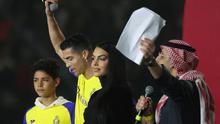 Cristiano Ronaldo bersama sang kekasih Georgina Rodriguez dan putranya Cristiano Ronaldo Jr naik panggung saat upacara penyambutan dirinya sebagai pemain baru Al Nassr di Stadion Mrsool Park, di ibu kota Saudi, Riyadh, Selasa (3/1/2023). (Fayez Nureldine / AFP)