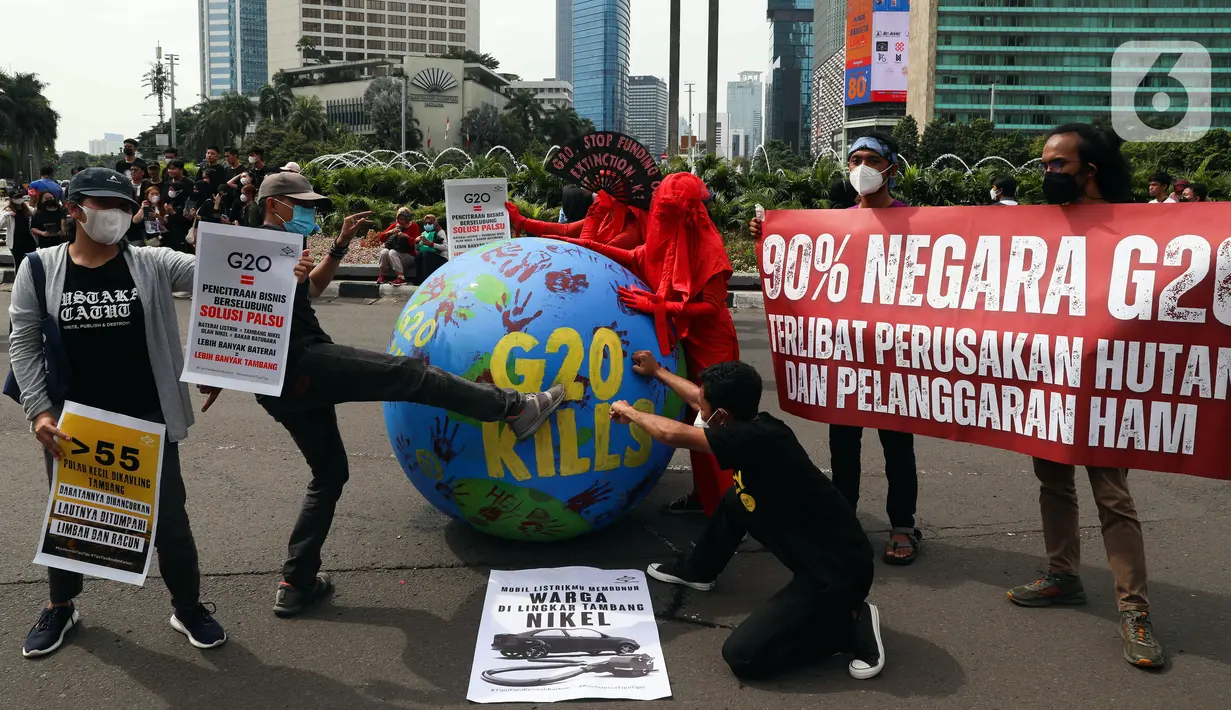 Aktivis iklim melakukan teatrikal dengan membawa bola dunia saat aksi di kawasan Bundaran Hotel Indonesia, Jakarta, Minggu (13/11/2022). Aksi yang digelar berbarengan dengan penyelenggaraan G20 ini meminta pemimpin dunia menemukan solusi bersama atas kondisi ekonomi global. (Liputan6.com/Herman Zakharia)