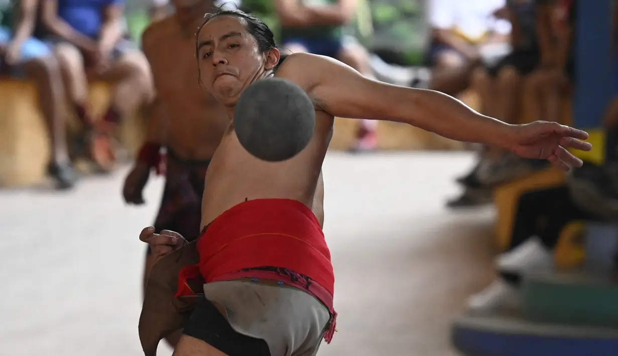 Seorang pria pribumi bermain selama final turnamen bola Maya di San Juan La Laguna, Solola, Guatemala, pada 18 September 2021. Sebanyak 12 tim, termasuk satu perempuan, berpartisipasi untuk mengklasifikasikan turnamen Mesoamerika yang akan diadakan di Meksiko pada Desember 2021. (Johan ORDONEZ/AFP)