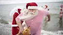 Seorang peserta Kongres Santa Claus Dunia 2015 bersiap berenang di pantai Bellevue di Copenhagen, Denmark, Minggu (21/7/2015). (REUTERS/Scanpix Denmark/Erik Refner)