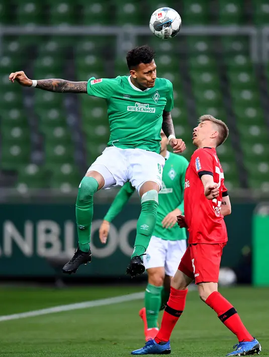 Pemain Werder Bremen Davie Selke (kiri) berebut bola dengan pemain Bayer Leverkusen Mitchell Weiser dalam pertandingan Bundesliga di Bremen, Jerman, Senin (18/5/2020). Bayer Leverkusen menang 4-1. (Stuart FRANKLIN/POOL/AFP)
