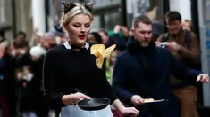 Seorang peserta ikut ambil bagian dalam acara tahunan Great Spitalfields Pancake Race untuk mengumpulkan uang bagi Ambulan Udara London di Inggris, Selasa (9/2). (REUTERS/Stefan Wermuth)