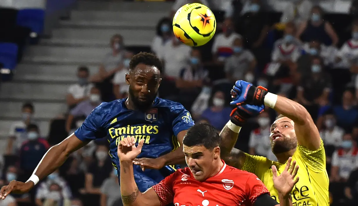 Penyerang Lyon, Moussa Dembele, berusaha menyundul bola saat menghadapi Nimes pada laga lanjutan Liga Prancis di Stadion Groupama, Sabtu (19/9/2020) dini hari WIB. Lyon bermain imbang 0-0 atas Nimes. (AFP/Jean-Philippe Ksiazek)