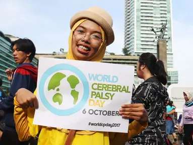 Relawan disabilitas membawa poster Peringatan Hari Cerebral Palsy Sedunia di area Car Free Day, Bundaran HI, Jakarta, Minggu (8/10). Kegiatan itu memperingati Hari Cerebral Palsy Sedunia yang jatuh pada tanggal 6 Oktober. (Liputan6.com/Angga Yuniar)