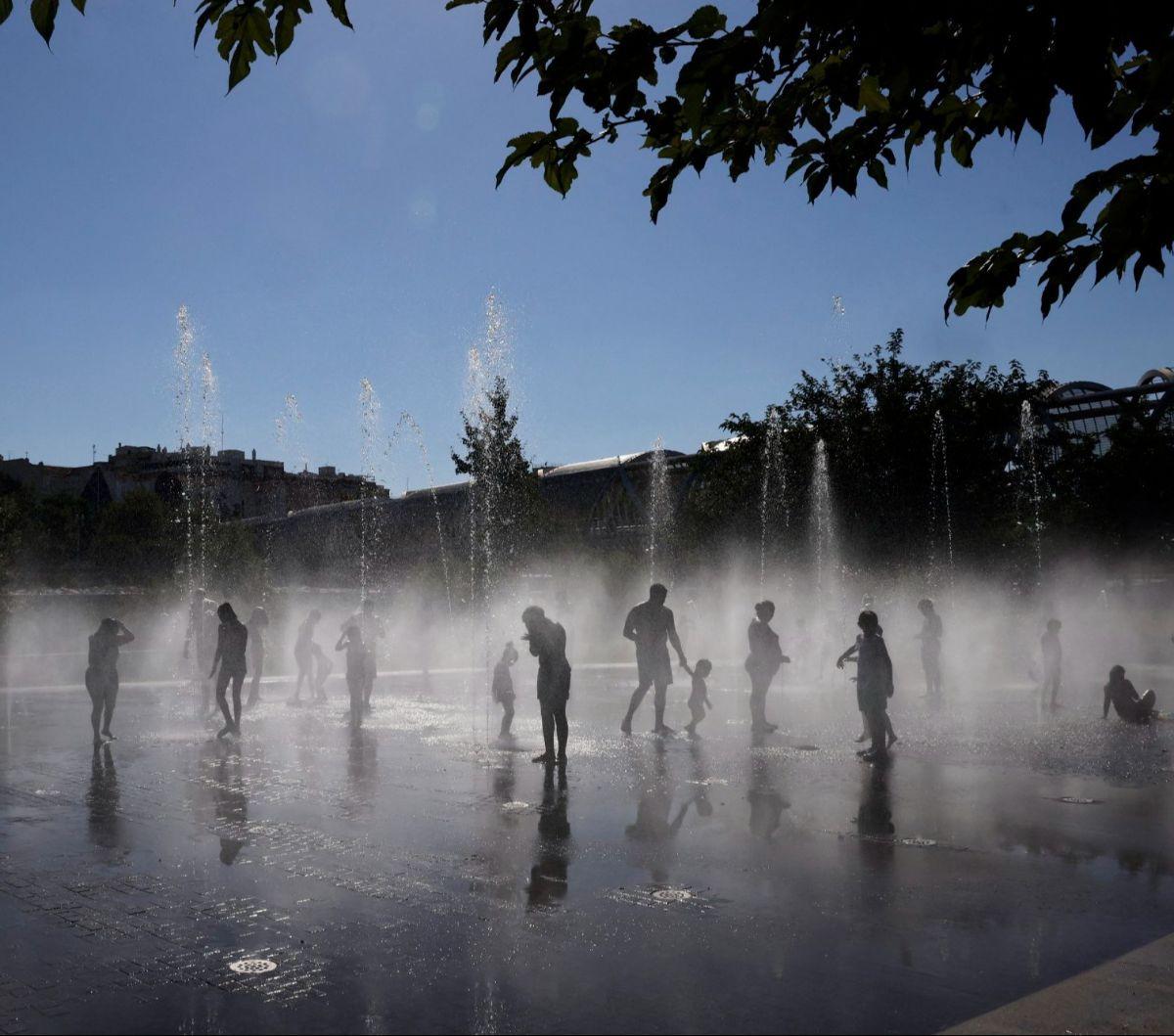 Sejumlah warga mandi di bawah guyuran air mancur di&nbsp;Taman Madrid Rio, Madrid, Spanyol, pada 23 Juli 2024. Spanyol dilanda gelombang panas dengan suhu diperkirakan bisa melampaui 40 derajat celcius selama musim panas tahun ini.&nbsp;Foto: Oscar Del Po