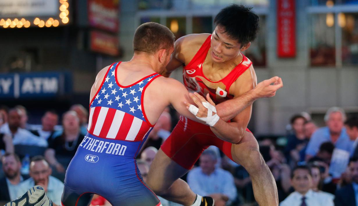 Pegulat Daichi Takatani asal Jepang berusaha mengunci Pegulat AS, Zain Retherford saat pertandingan gulat "Beat the Streets" di New York Times Square, (17/5). Kompetisi gulat ini digelar sebagai program gulat atletik New York. (AP Photo/Kathy Willens)