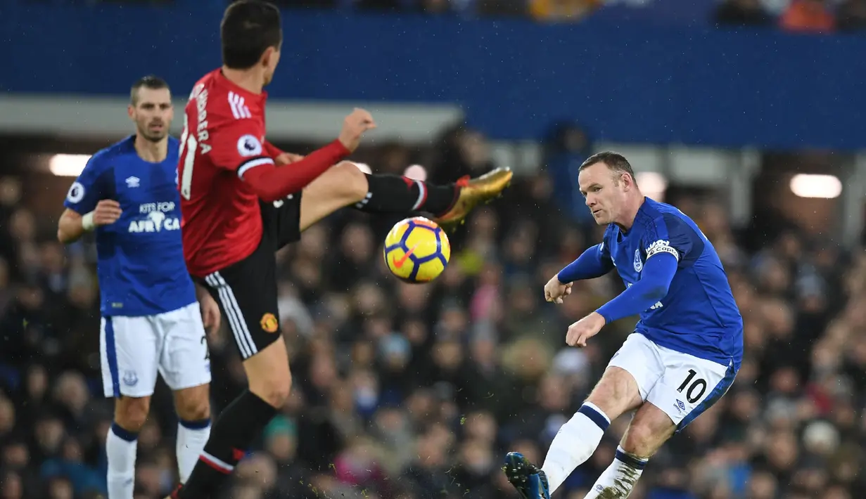 Aksi pemain Everton, Wayne Rooney (kanan) melakukan tembakan melewati adangan pemain Manchester United, Ander Herrera pada lanjutan Premier League di Goodison Park, Liverpool, (1/1/2018). MU menang 2-0. (AFP/Paul Ellis)