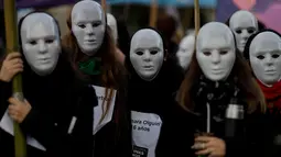Demonstran mengenakan topeng saat unjuk rasa menentang kekerasan gender di Buenos Aires, Argentina, Sabtu (3/6). Demonstran menuntut agar pemerintah mengambil tindakan tegas terhadap pelaku kekerasan gender. (Foto AP / Natacha Pisarenko)