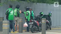 Driver ojek online berbincang di kawasan Jakarta, Jumat (10/4/2020). Peraturan Gubernur DKI Jakarta dalam pelaksanaan PSBB mengatur angkutan roda dua seperti ojek online maupun ojek konvensional dilarang membawa penumpang.  (Liputan6.com/Herman Zakharia)