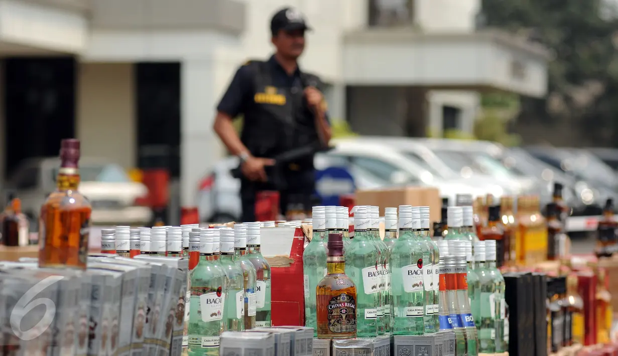 Petugas Ditjen Bea Cukai berjaga disisi ribuan botol minuman keras yang akan dimusnahkan Jakarta, Selasa (6/10/2015). Ditjen Bea Cukai berhasil mengamankan 12.967 botol miras dan dua juta batang rokok illegal. (Liputan6.com/Helmi Fithriansyah)