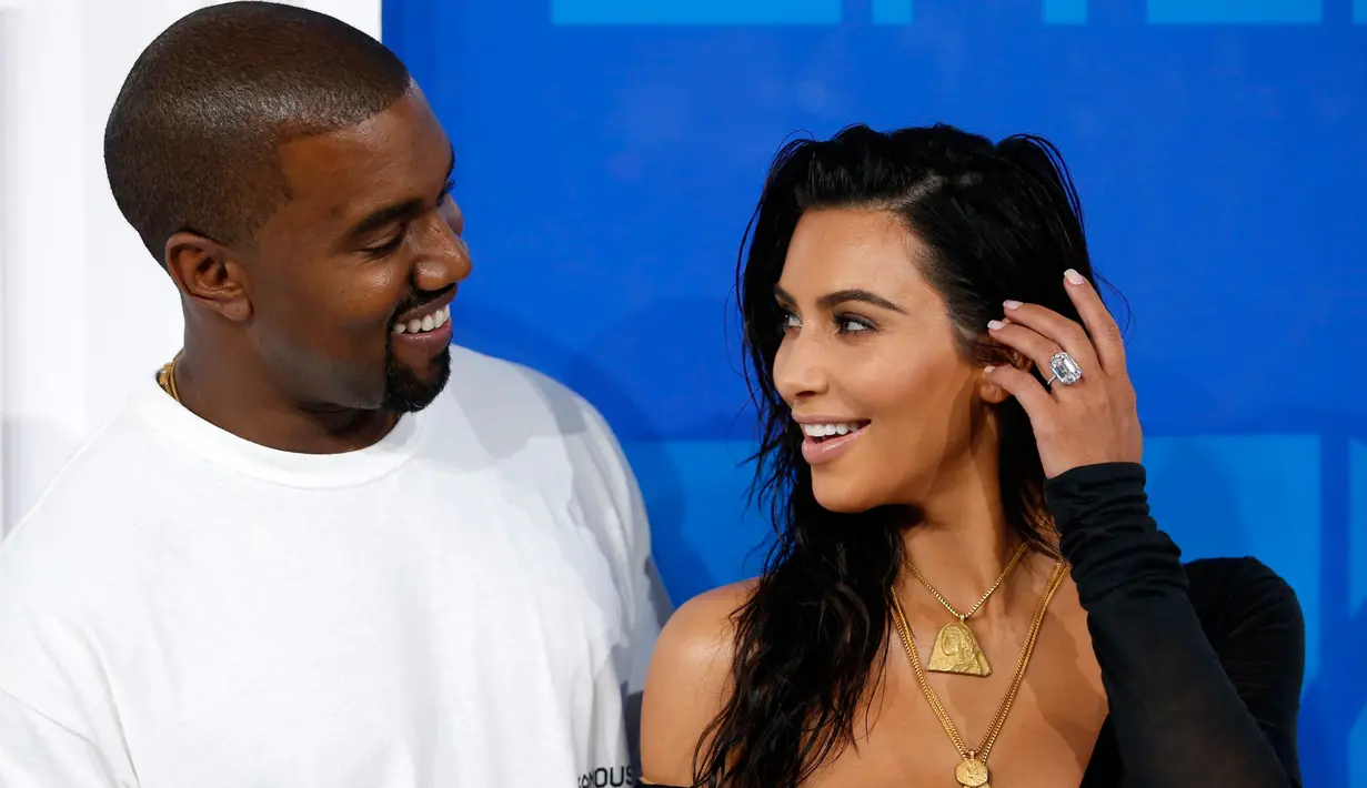 Senyum Kim Kardashian dan Kanye West saat berpose di karpet merah penghargaan MTV VMA 2016 di New York, Minggu (28/8). Pasangan seleb itu memilih busana yang lebih santai untuk menghadiri ajang penghargaan tersebut. (REUTERS/Eduardo Munoz)