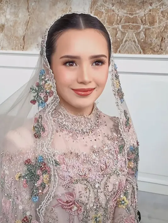 Dress cantik ini dipadukan dengan veil tipis berwarna cokelat dan payet warna-warni di bagian pinggir [@wirantikurniabride]