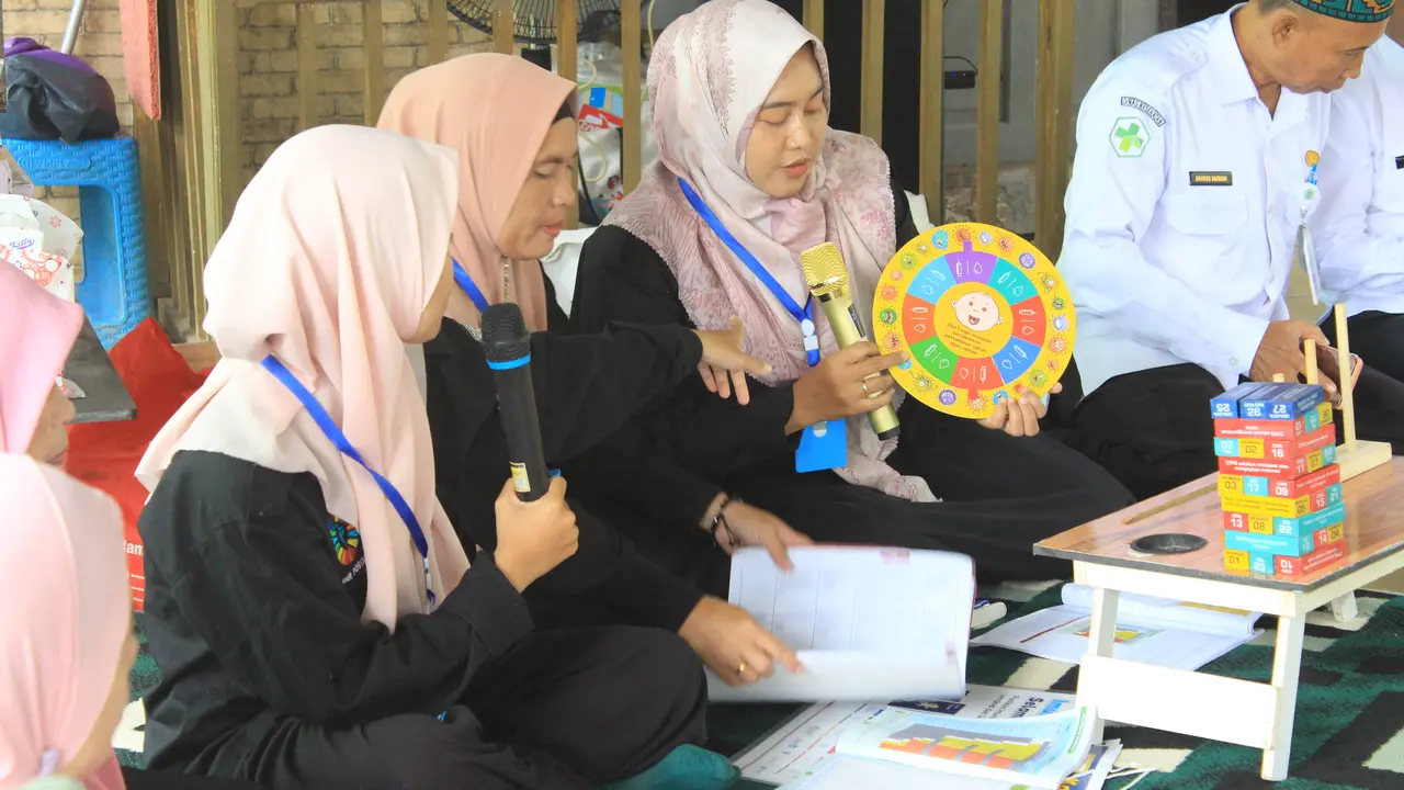 Kader kesehatan saat memberikan edukasi dibantu alat agar mudah dipahami masyarakat.