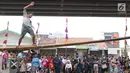 Anak-anak bermain lomba jalan di atas batang pohon pinang di sekitar Kalimalang, Jakarta, Sabtu (17/8/2019). Beragam lomba permainan digelar warga untuk menyemarakkan HUT ke-74 Republik Indonesia. (Liputan6.com/Helmi Fithriansyah)