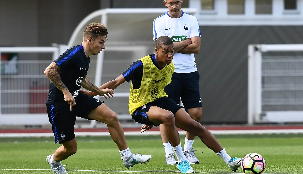 Striker AS Monaco, Kylian Mbappe, berusaha melewati Lucas Digne saat mengikuti pemusatan latihan bersama Timnas Prancis di Clairefontaine, Yvelines, Selasa (30/5/2017). (AFP/Franck Fife)