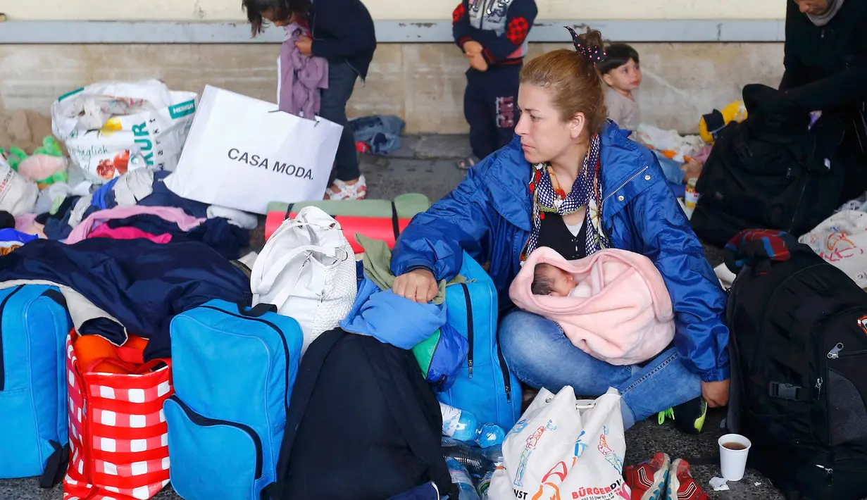 Imigran perempuan bersama anaknya saat beristirahat di Stasiun Wina, Austria, Sabtu (5/9/2015). Sekitar 2.000 imigran menembus Austria setelah pemerintah Hungaria mengizinkan para pencari suaka ke negara selanjutnya. (REUTERS/Heinz-Peter Bader)