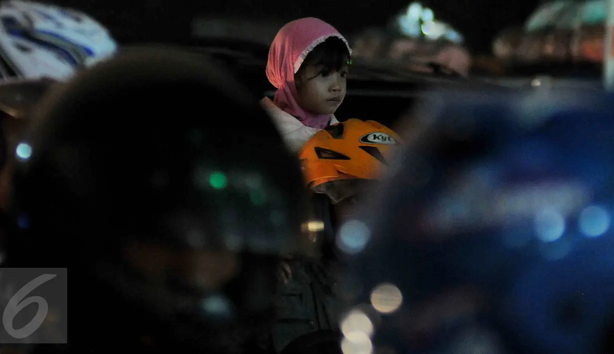 Seorang anak kecil ikut mudik dengan menggunakan motor di Pelabuhan Merak, Banten, Rabu dinihari (15/7/2015). KPAI meminta pemudik yang menggunakan sepeda motor tidak membawa anak karena sangat membahayakan. (Liputan6.com/Johan Tallo) 