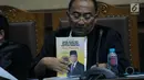 Penasehat hukum Ttrdakwa korupsi proyek e-KTP, Setya Novanto memperlihatkan buku yang dibagikan pada sidang pembacaan nota pembelaan di Pengadilan Tipikor, Jakarta, Jumat (13/4). Sidang mendengar pledoi terdakwa. (Liputan6.com/Helmi Fithriansyah)