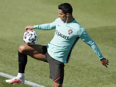 Penyerang Portugal, Cristiano Ronaldo mengontrol bola saat mengikuti sesi latihan tim di Oeiras, luar Lisbon, Kamis (3/6/2021). Portugal akan menghadapi Spanyol dalam pertandingan persahabatan internasional pada Sabtu (5/6/2021). (AP Photo/Armando Franca)