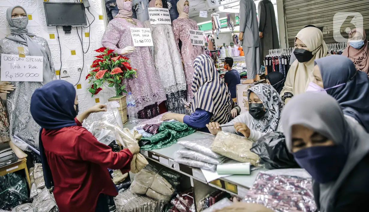Pedagang melayani pembeli di Pasar Tanah Abang, Jakarta, Minggu (10/10/2021). Dilonggarkannya kebijakan PPKM di Jakarta membuat aktivitas perdagangan di Pasar Tanah Abang kembali bangkit. (Liputan6.com/Faizal Fanani)