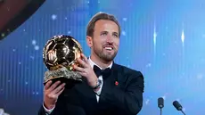 Pesepak bola Inggris, Harry Kane, memegang trofi penghargaan pemain terbaik saat menghadiri acara penganugerahan Ballon d’Or di London Palladium Theatre, London, Inggris, Senin (26/10/2026). (AP Photo/Kin Cheung)
