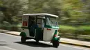 Bajaj 'Eleric-Auto' saat mengangkut seorang kamerawan di Bangalore, India, Sabtu (5/3). Di India 20 persen masyarakatnya menggunakan transportasi umum untuk berpergian dan Bajaj 'Eleric-Auto' salah satunya. MANJUNATH KIRAN / AFP)