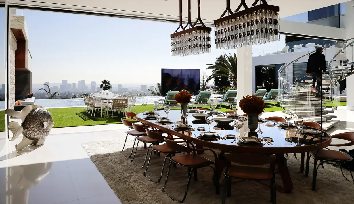 Suasana ruang makan di dalam dan luar ruangan di kawasan Bel-Air, Los Angeles,AS (26/1). Rumah ini memiliki ruang spa dan kolam renang dengan pemandangan kota Los Angeles. (AP/Jae C. Hong)