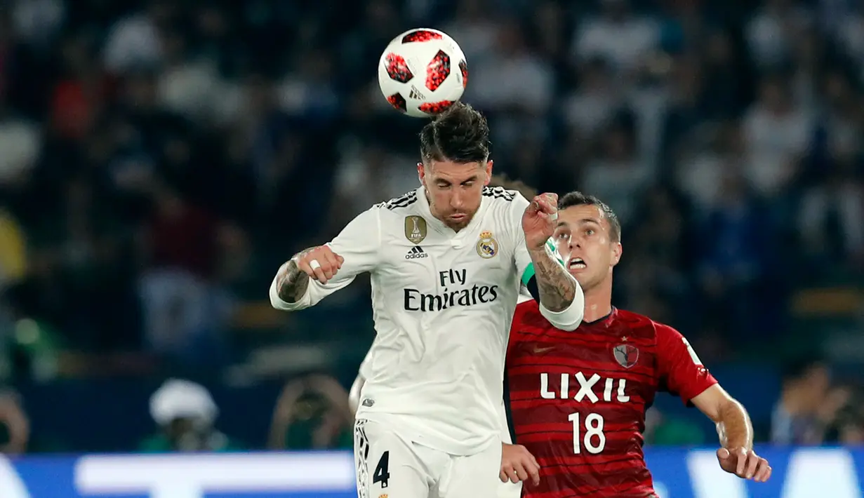 Bek Real Madrid, Sergio Ramos berebut bola udara dengan pemain Kashima Antlers, Serginho selama semifinal Piala Dunia Antarklub 2018 di stadion Zayed Sports City, Uni Emirat Arab (19/12). Madrid menang 3-1. (AP Photo/Hassan Ammar)
