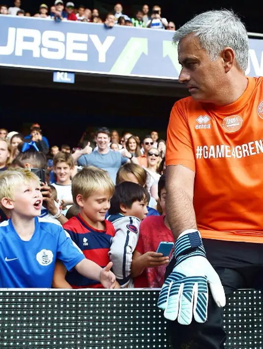 Pelatih MU, Jose Mourinho berbincang dengan anak kecil saat berpartisipasi dalam laga amal di stadion Loftus Road QPR di London, (2/8). Di pertandingan ini Mourinho menjadi kiper tim Shearer. (Instagram/mourinho_z) 