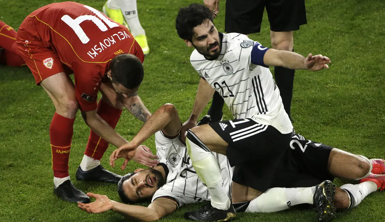 Gelandang Jerman, Emre Can mengalami cedera usai terlibat benturan dengan pemain Makedonia Utara dalam laga lanjutan Kualifikasi Piala Dunia 2022 Zona Eropa Grup J di Duisburg, Jerman, Rabu (31/3/2021). Jerman kalah 1-2 dari Makedonia Utara. (AP/Thilo Schmuelgen/Pool)