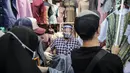 Pedagang menggunakan alat pelindung wajah (Face Shield) saat melayani pembeli di Kawasan Tanah Abang, Jakarta, Senin (18/5/2020). Penggunaan alat pelindung wajah itu sebagai upaya untuk melindungi diri saat berhubungan dengan pembeli dalam pecegahan penyebaran COVID-19. (Liputan6.com/Faizal Fanani)