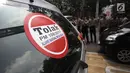 Striker penolakan Permenhub Nomor 108 terpasang di mobil sopir taksi online yang terparkir di Jalan Medan Merdeka Barat, Jakarta, Rabu (14/2). Para pengemudi menolak Permenhub Nomor 108 karena dianggap memberatkan. (Liputan6.com/Arya Manggala)