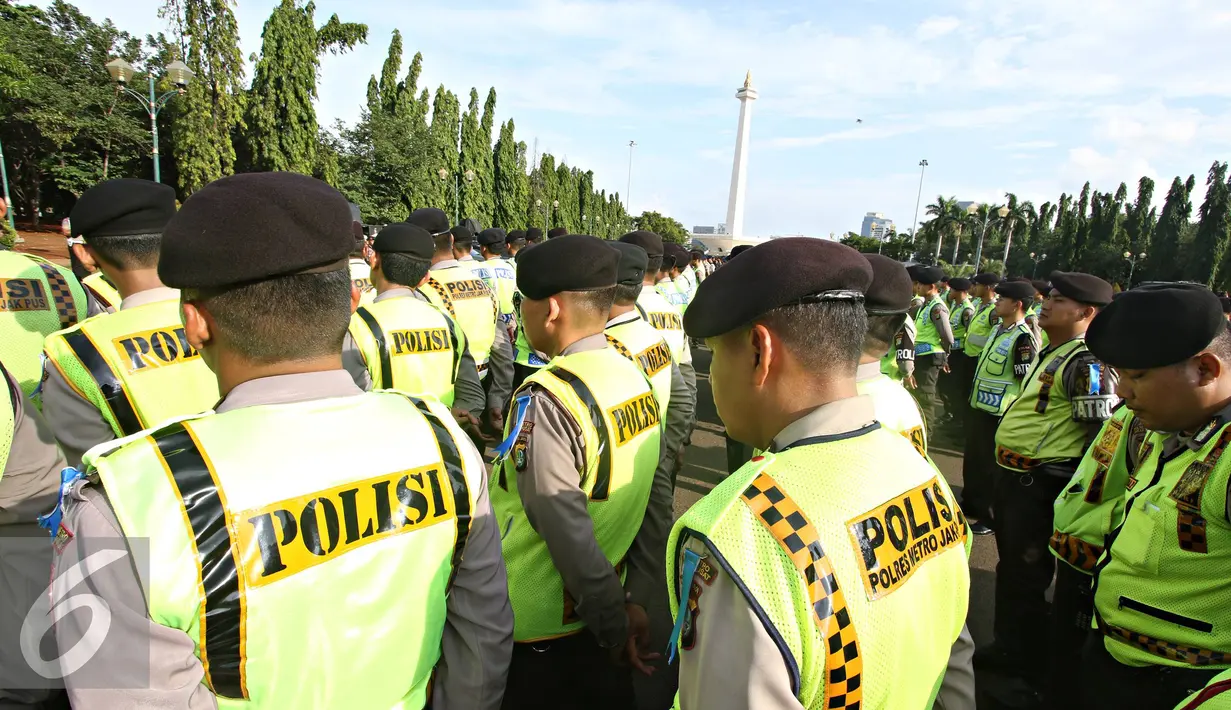 Petugas kepolisian mengikuti apel gabungan di Monas, Jakarta, Kamis (31/12). Sebanyak 1300 personel gabungan yang terdiri dari polisi, TNI, Pol PP, dan Pramuka dikerahkan untuk mengamankan perayaan malam tahun baru. (Liputan6.com/Immanuel Antonius)
