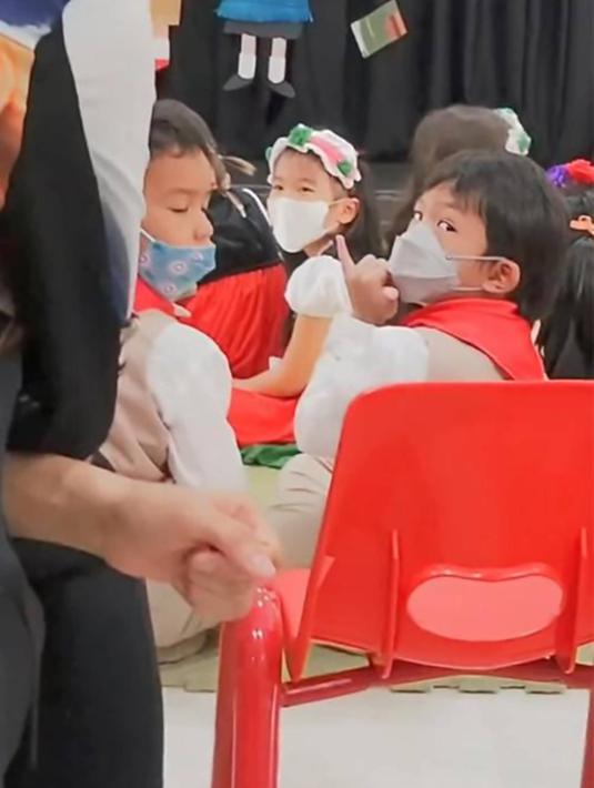 Dalam acara sekolah anak keduanya ini, terlihat Aqlan yang melihat ke hadapan orang tuanya ini memberikan tanda isyarat yang berarti I Love You. Sebuah kebiasaan simpel namun memiliki arti yang dalam dalam keluarga tentu membuat keluarga ini terlihat semakin harmonis. (Liputan6.com/IG/@mrsayudewi)