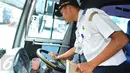 Petugas Dirjen Perhubungan melakukan pemeriksaan instrumen kemudi pada bus yang akan digunakan sebagai angkutan mudik lebaran 2015 di Terminal Pulogadung, Jakarta, Jumat (10/7). (Liputan6.com/Herman Zakharia)